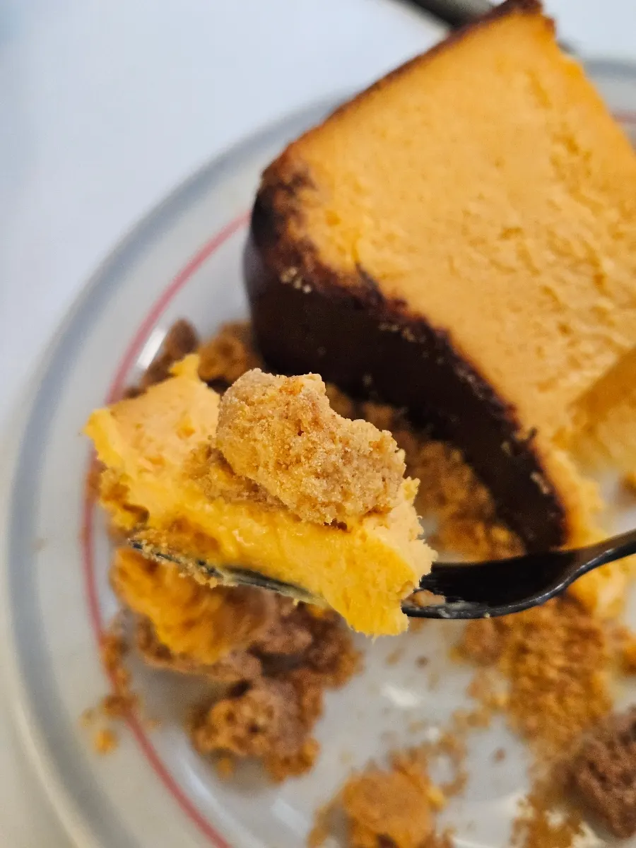 A bite of cheesecake with honey cheese crumble topping
