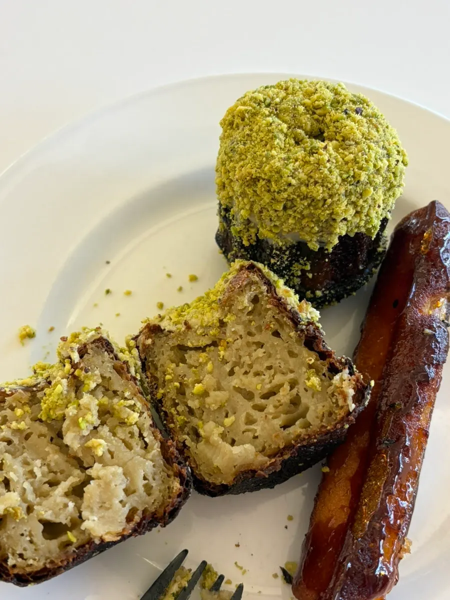 Cross-section of pistachio canelé with coffee