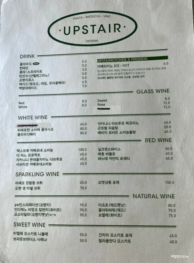 Menu board listing pasta and steak prices