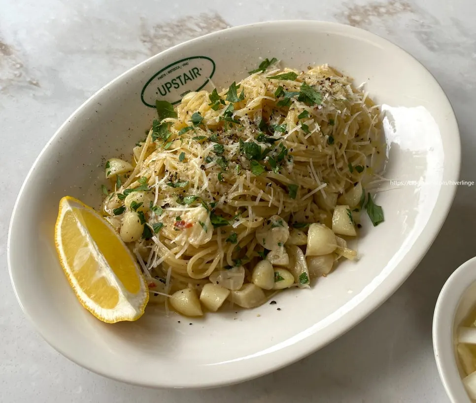 A plate of aglio olio pasta at Upstairs Kitchen