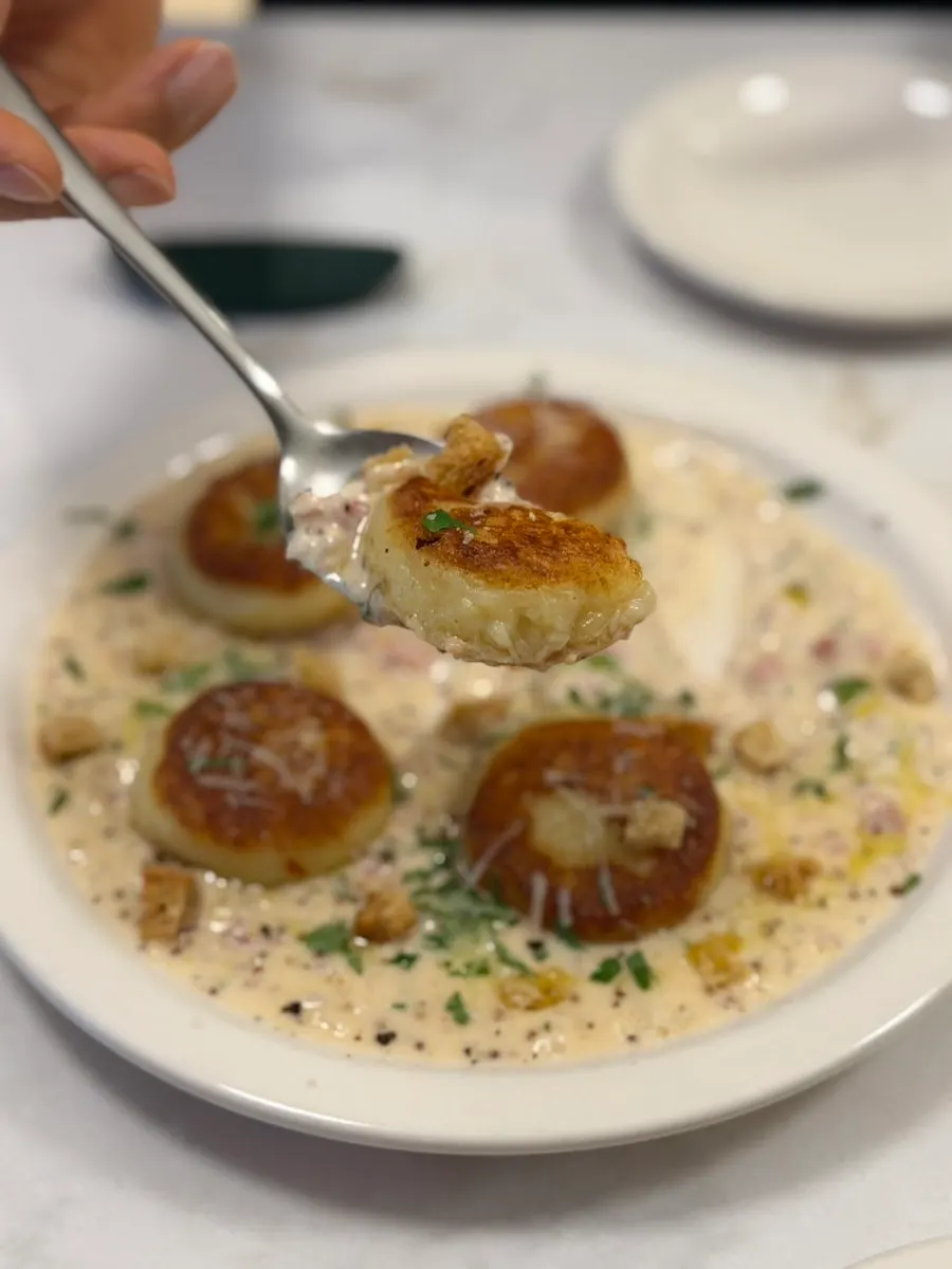 A bite of gnocchi coated in cream sauce