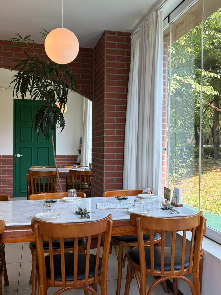 Interior view with trees visible through the floor-to-ceiling window