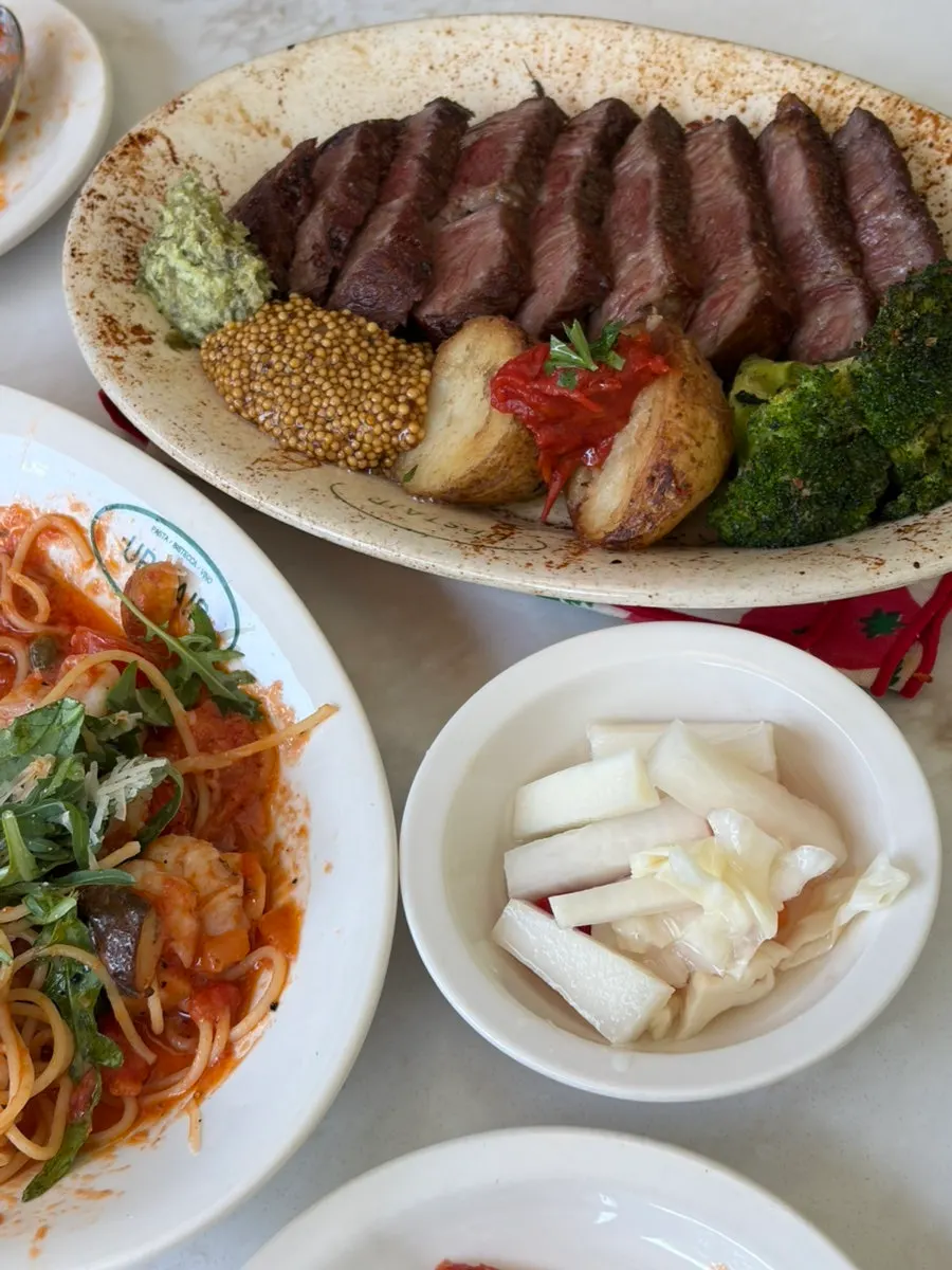Table spread with the ordered pasta and steak