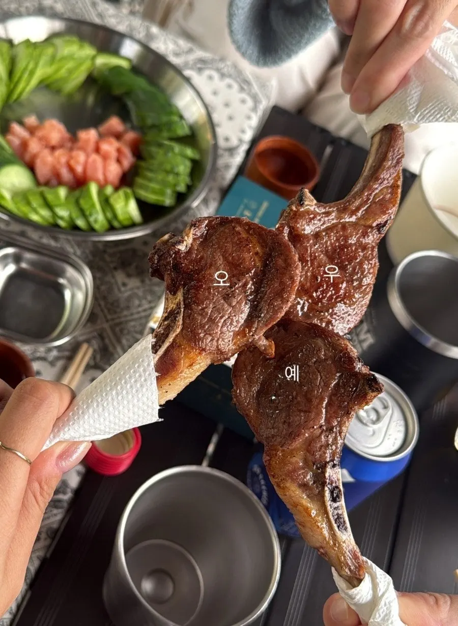 Lamb ribs grilling on a charcoal plate