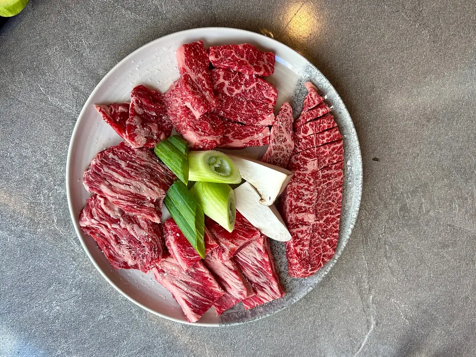 A plate of four wagyu cuts with visible marbling