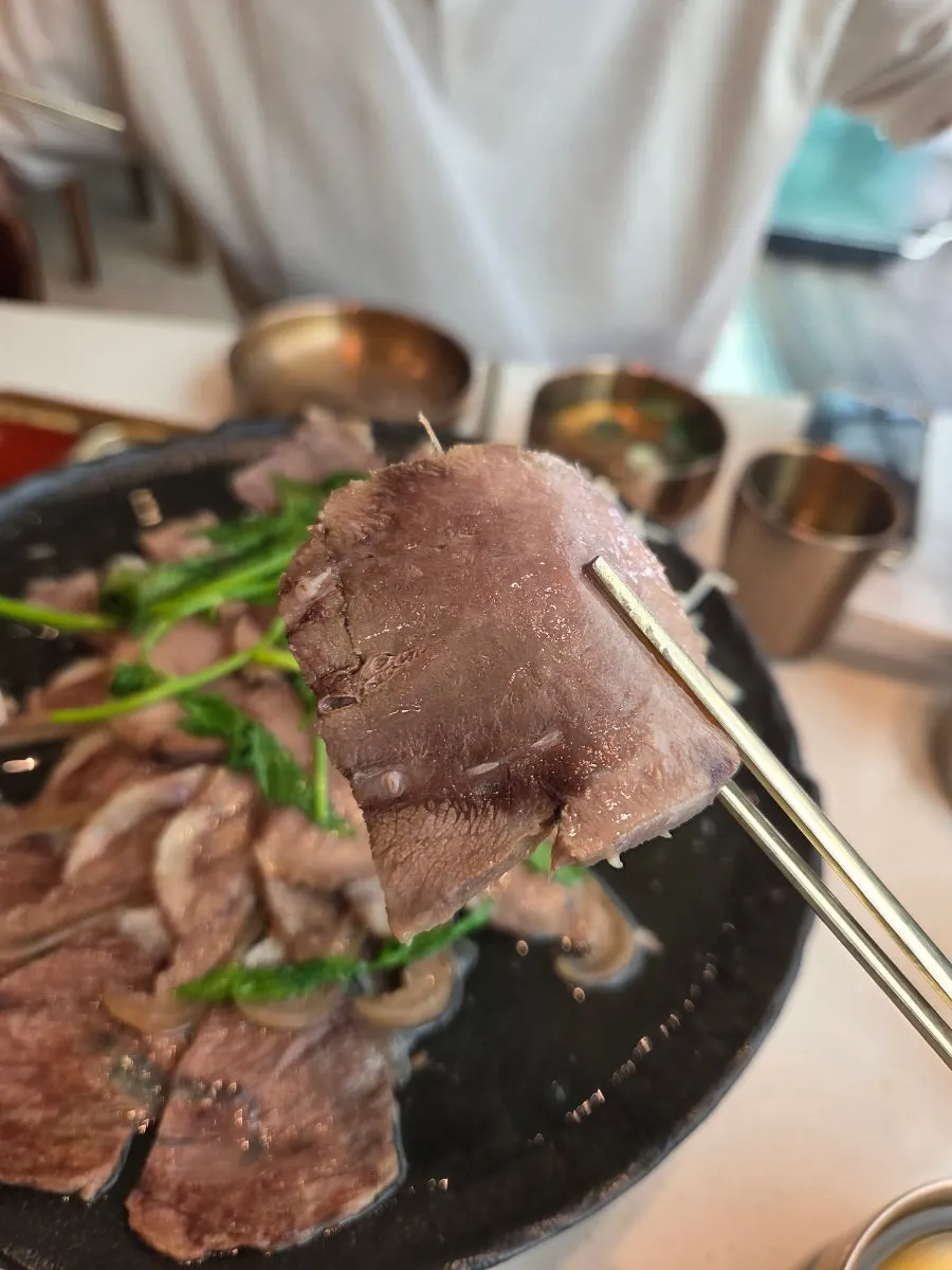 Korean beef suyuk served with minari and enoki mushrooms