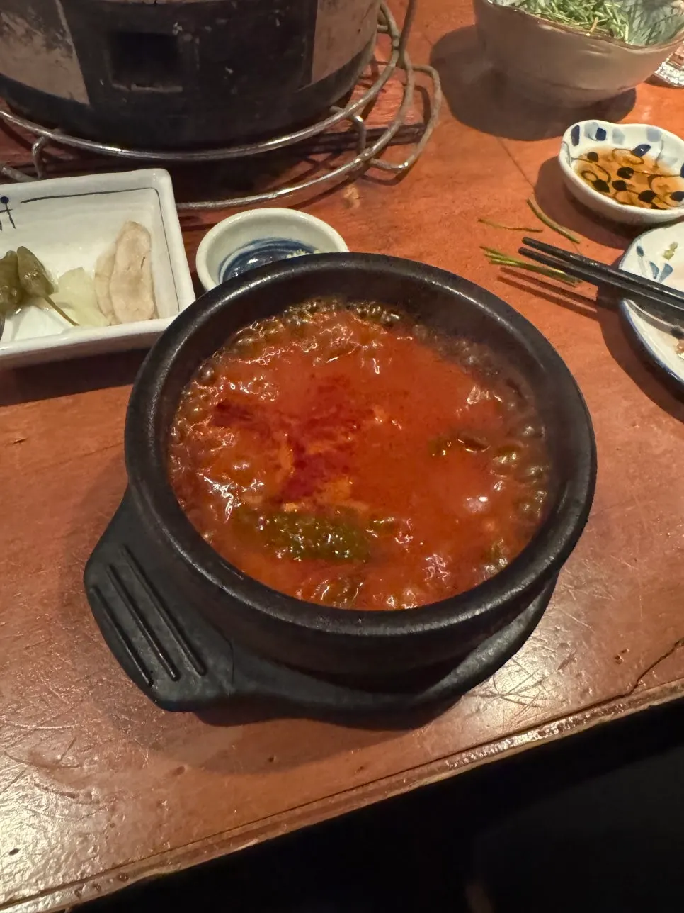 Stewed aged kimchi in a stone pot with rice and seaweed flakes