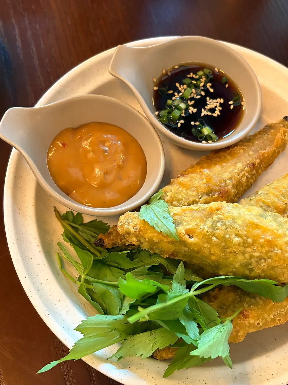 Red sauce and soy sauce served alongside the fried peppers