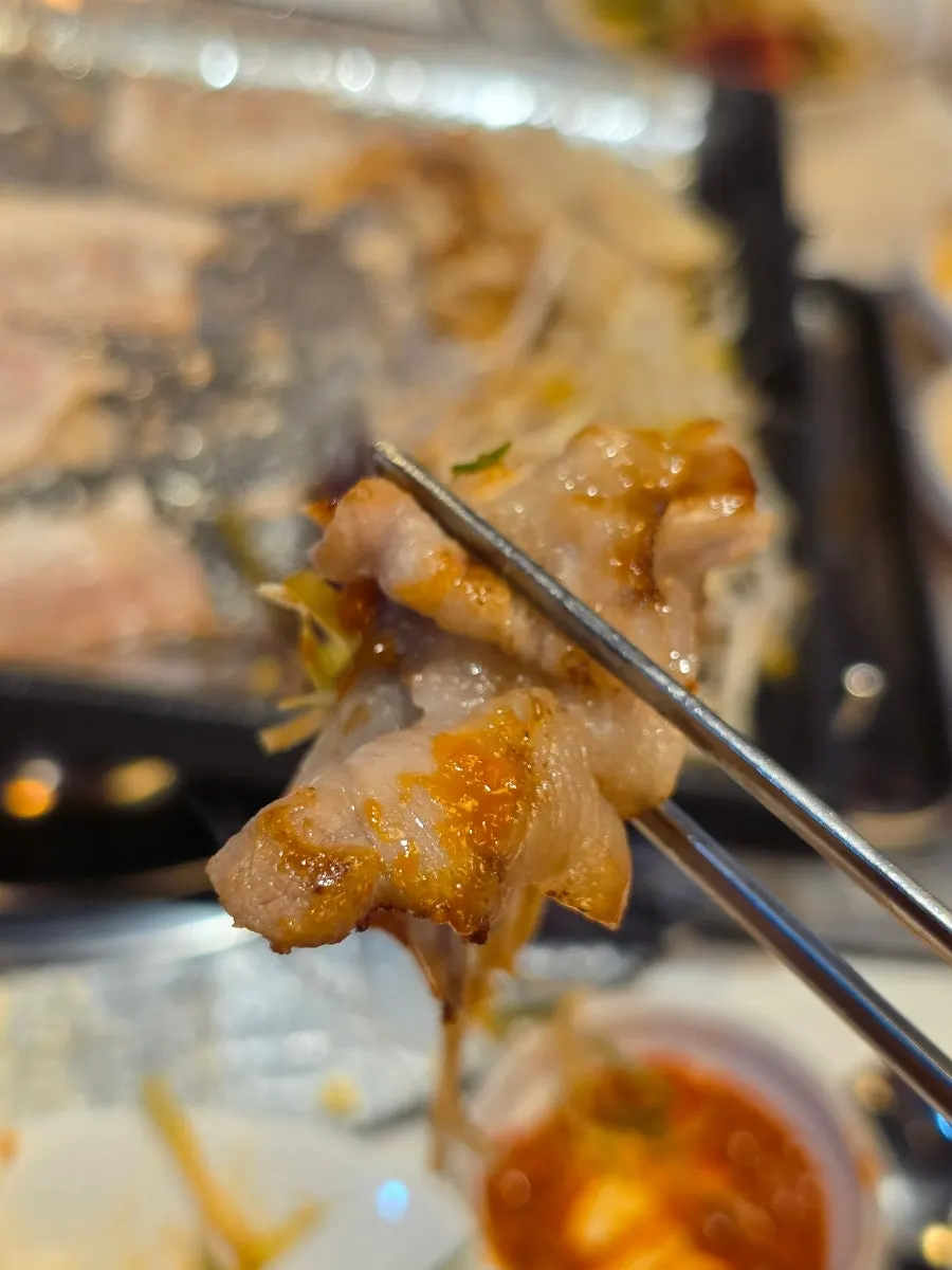 Grill plate full of cooked frozen pork belly and side dishes