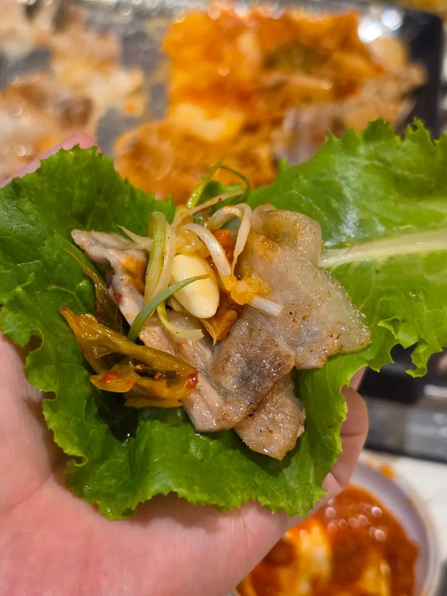 A wrap of frozen pork belly in lettuce