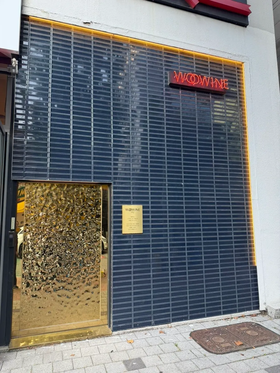 Entrance of Woowine with a dark exterior and golden sign