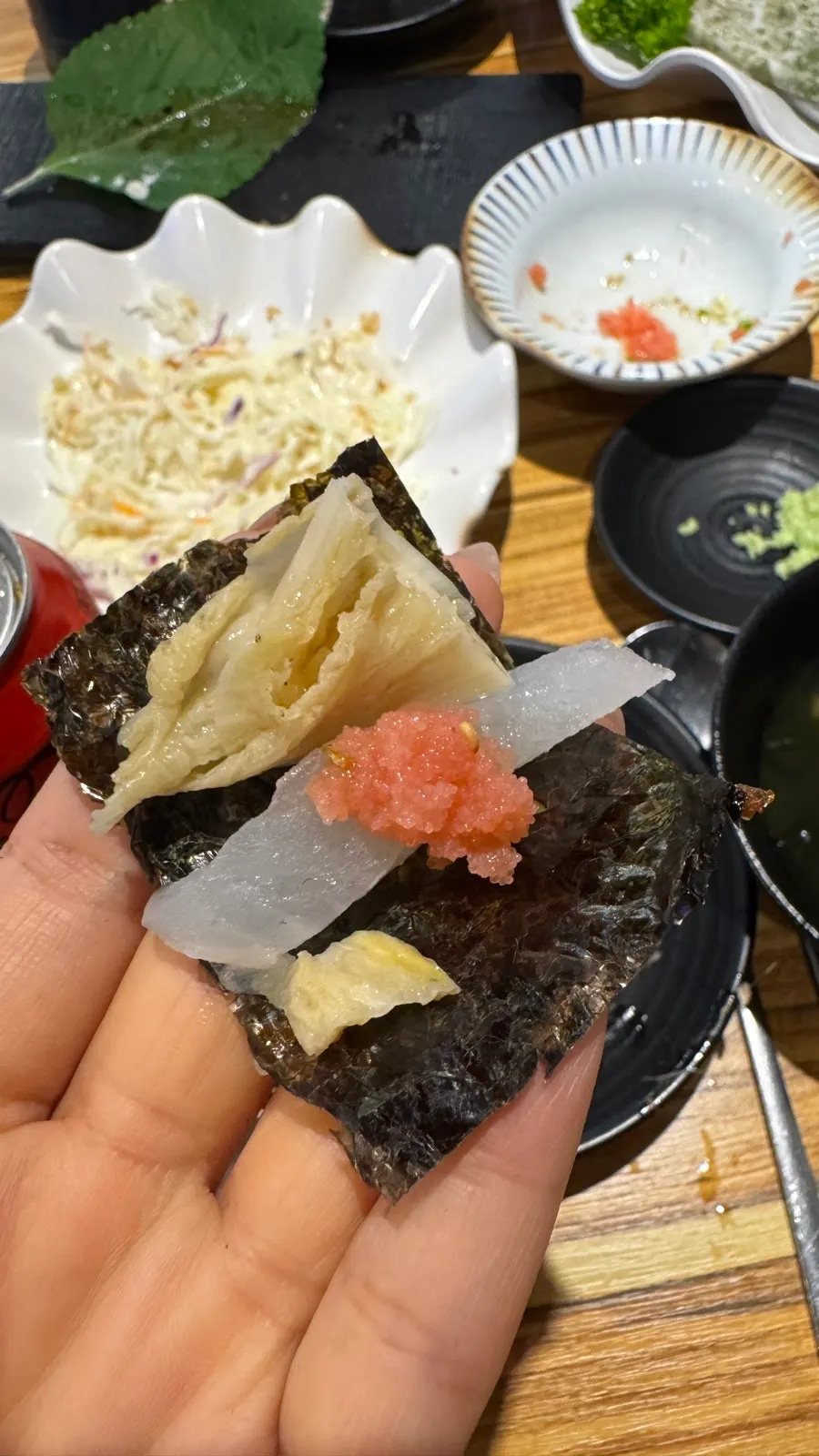 A piece of sashimi topped with salted pollock roe