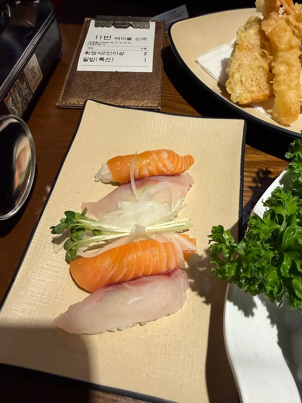 A sushi platter topped with generous slices of fish