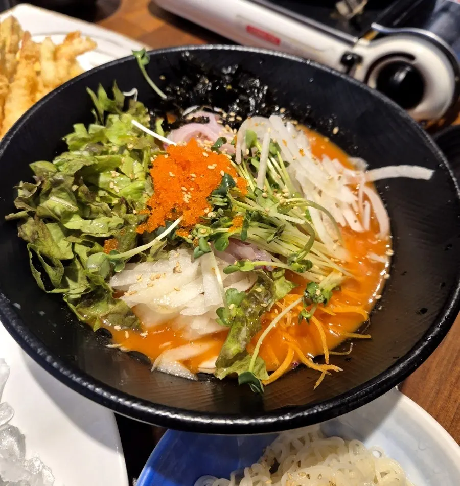 A ladle scooping up the spicy stew broth