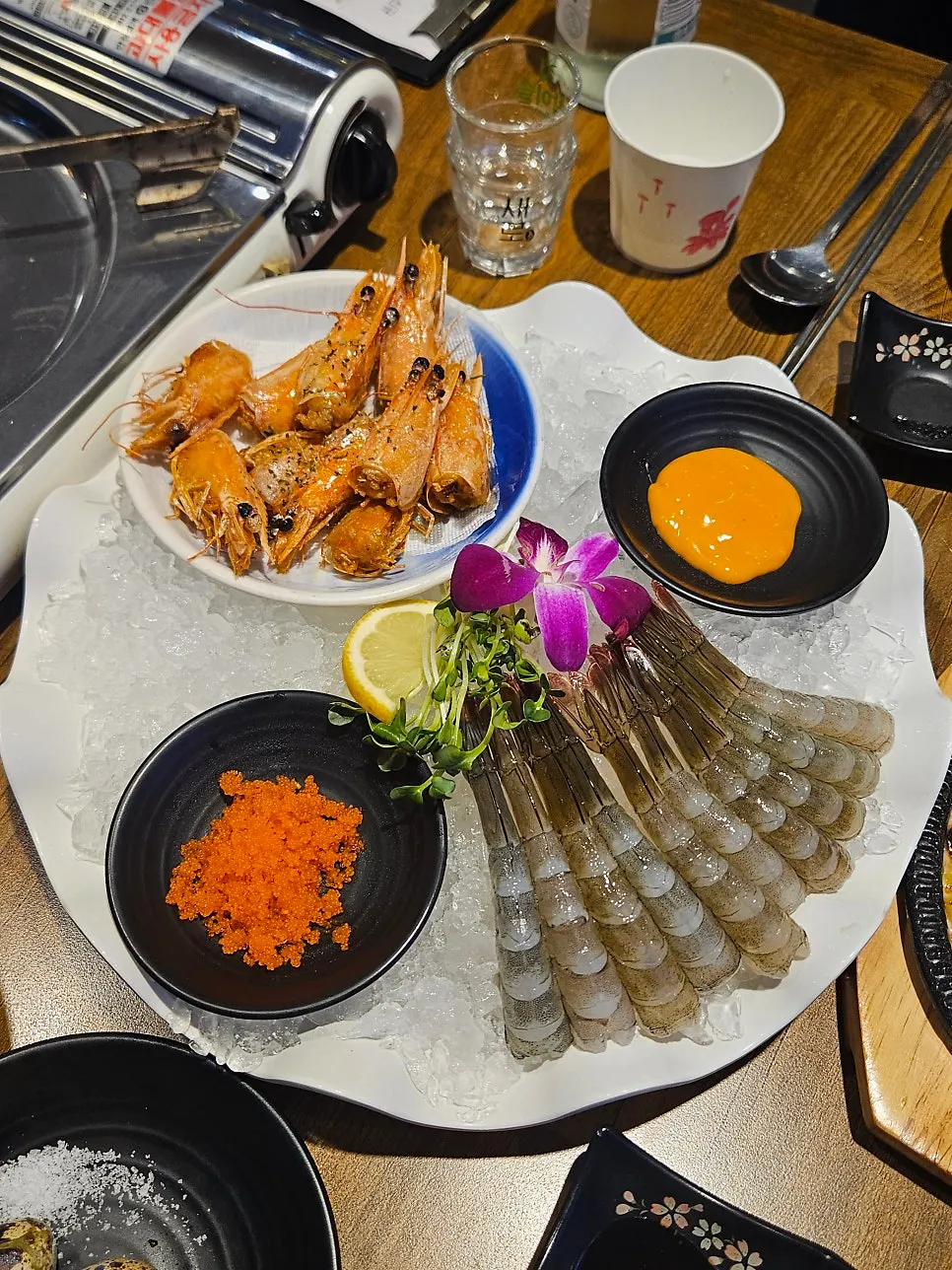 Plate of mini shrimp sashimi and grilled shrimp heads
