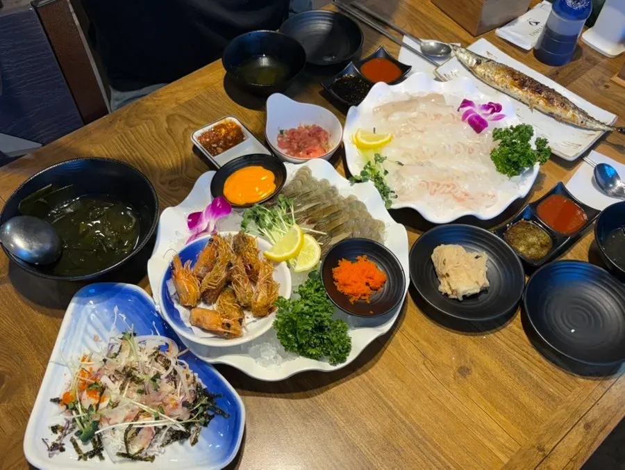 Table spread with flounder sashimi and raw shrimp sashimi together
