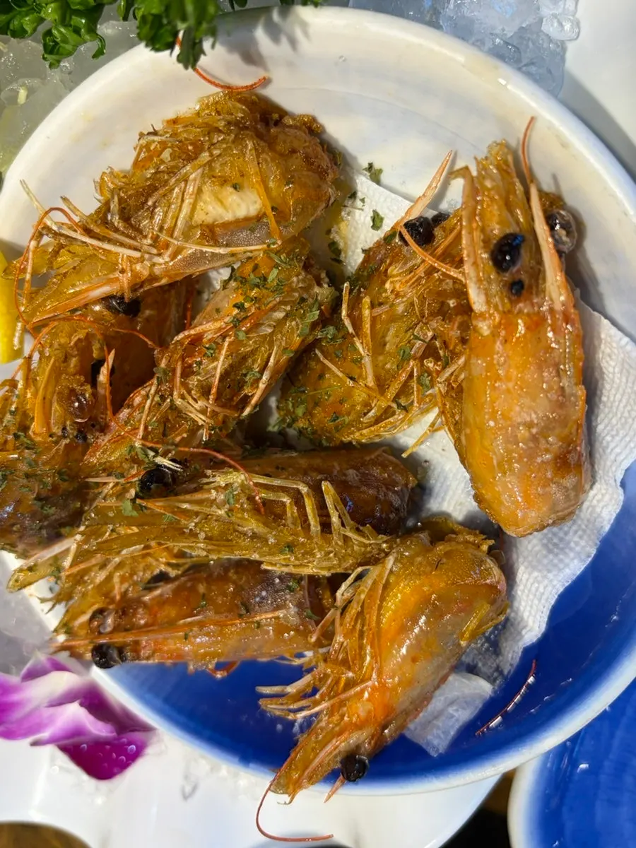 Grilled shrimp heads served alongside the mini raw shrimp sashimi