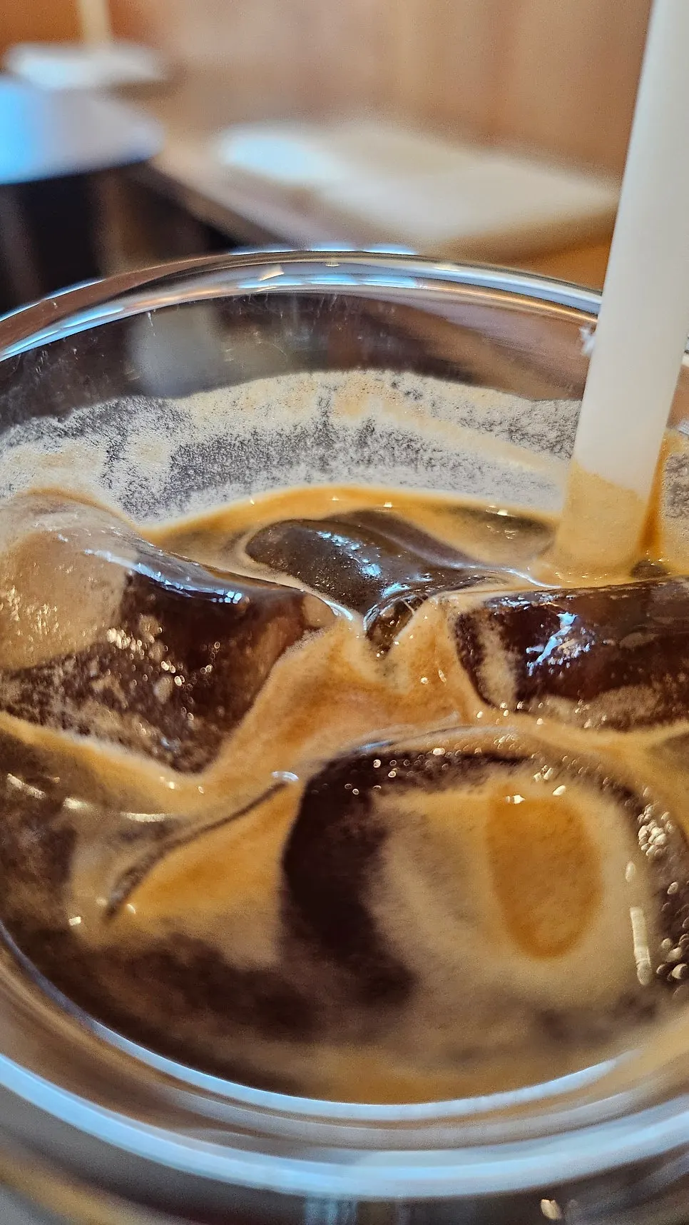 A glass of iced americano with ice cubes