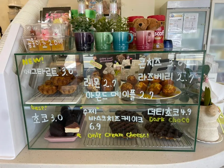 Display case with egg tarts, madeleines, and other baked goods