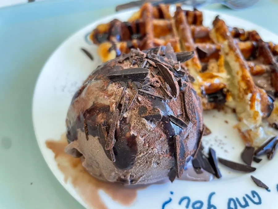 Close-up of croffle topped with chocolate syrup and chips