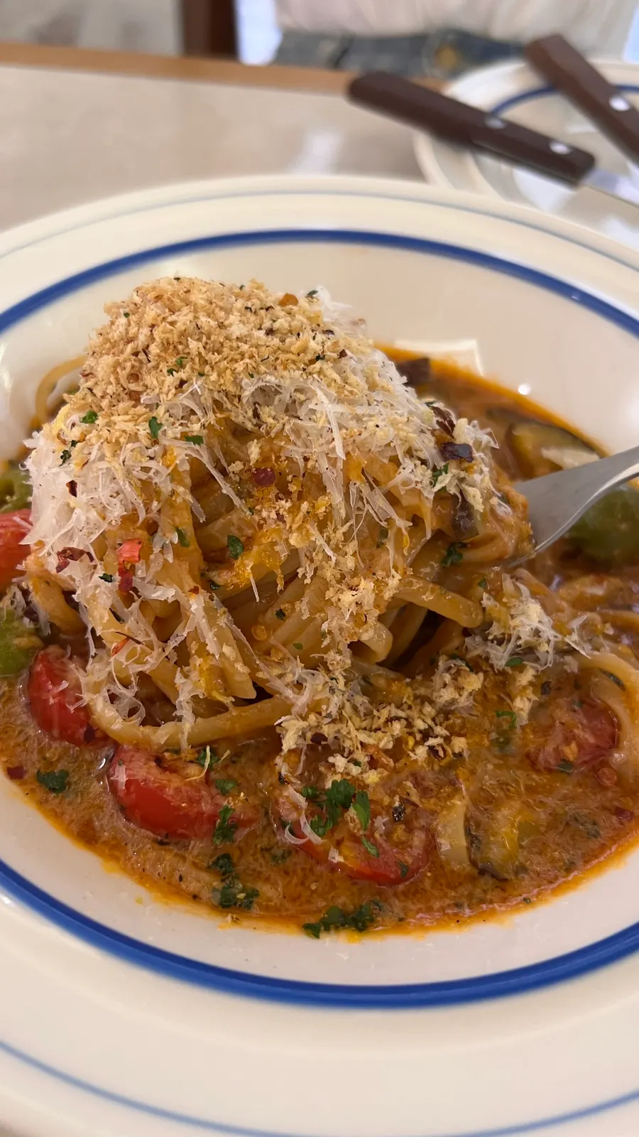 Puttanesca pasta topped with snowy shredded cheese