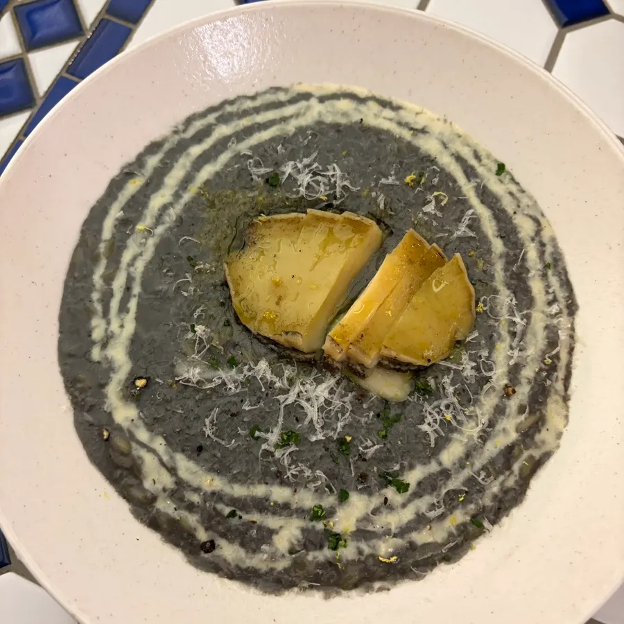 Squid-ink risotto topped with abalone