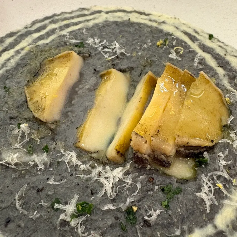 Scooping a portion of the squid-ink risotto