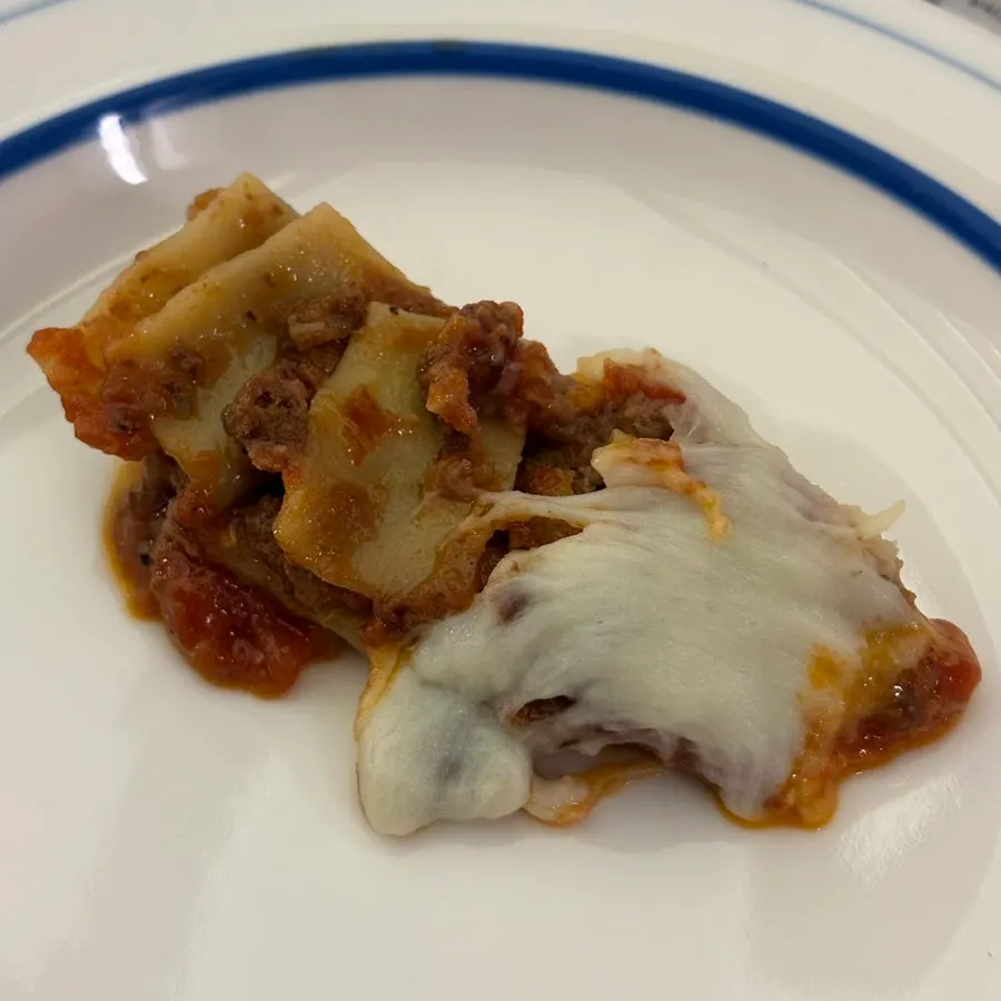 A slice of lasagna showing the ragù sauce