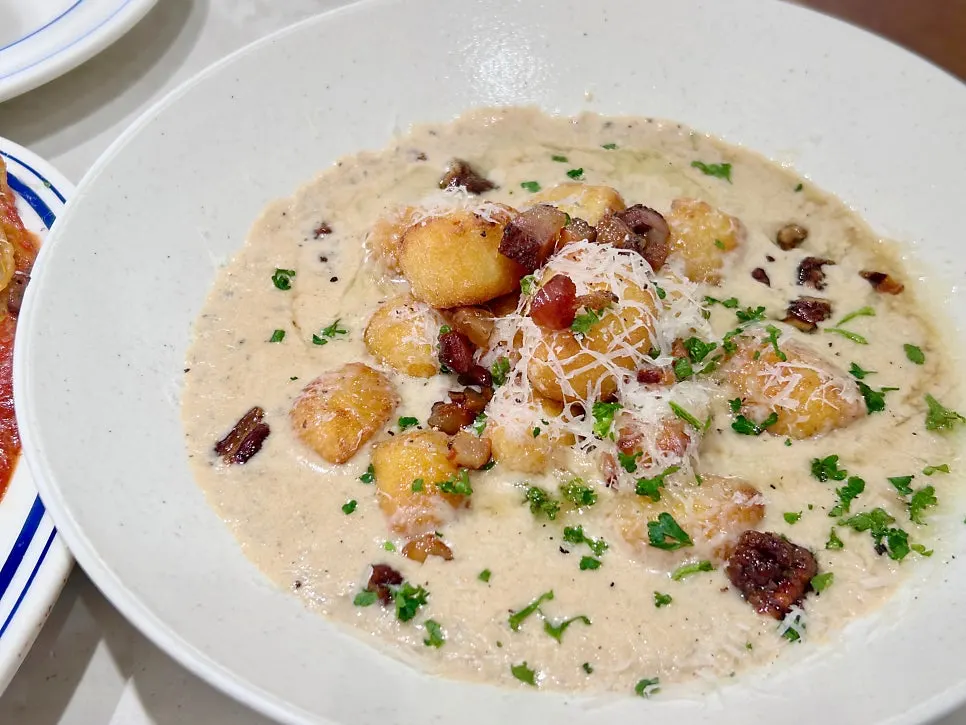 Close-up of gnocchi coated in cream sauce