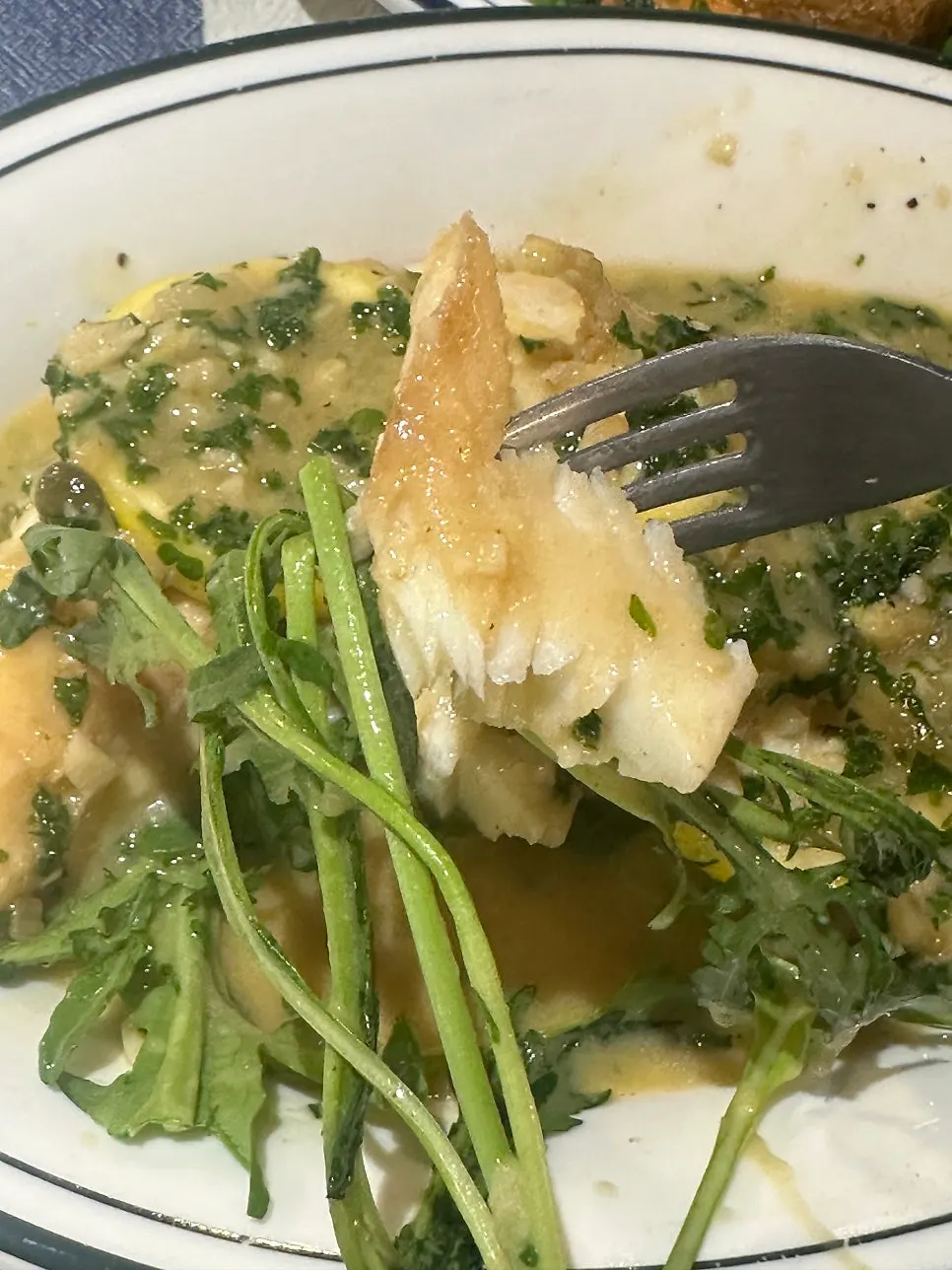A piece of fish steak served with arugula