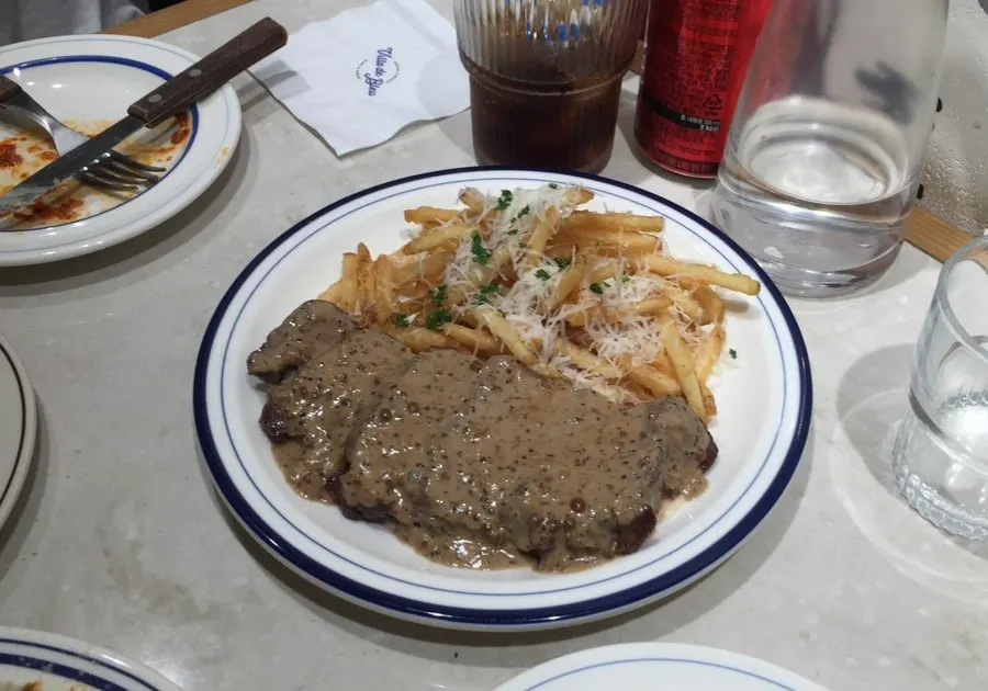 직원이 라자냐 위에 알리고 치즈를 올리는 장면