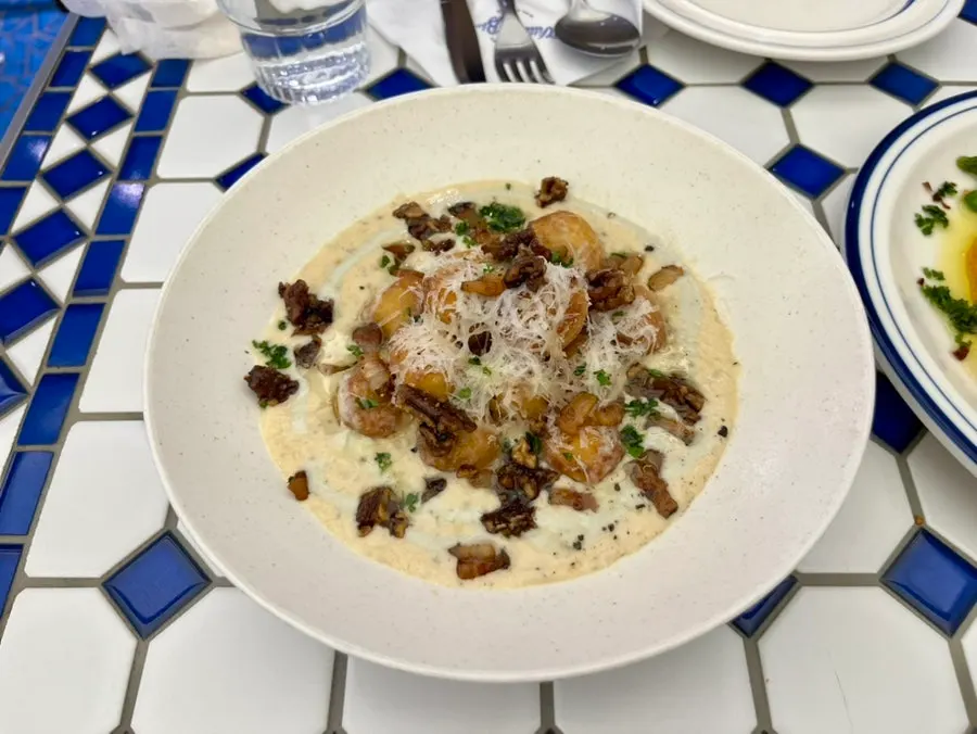 Close-up of pollo mambo topped with octopus and peas