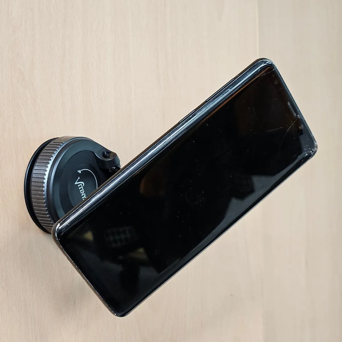 Smartphone stand suctioned onto exercise equipment
