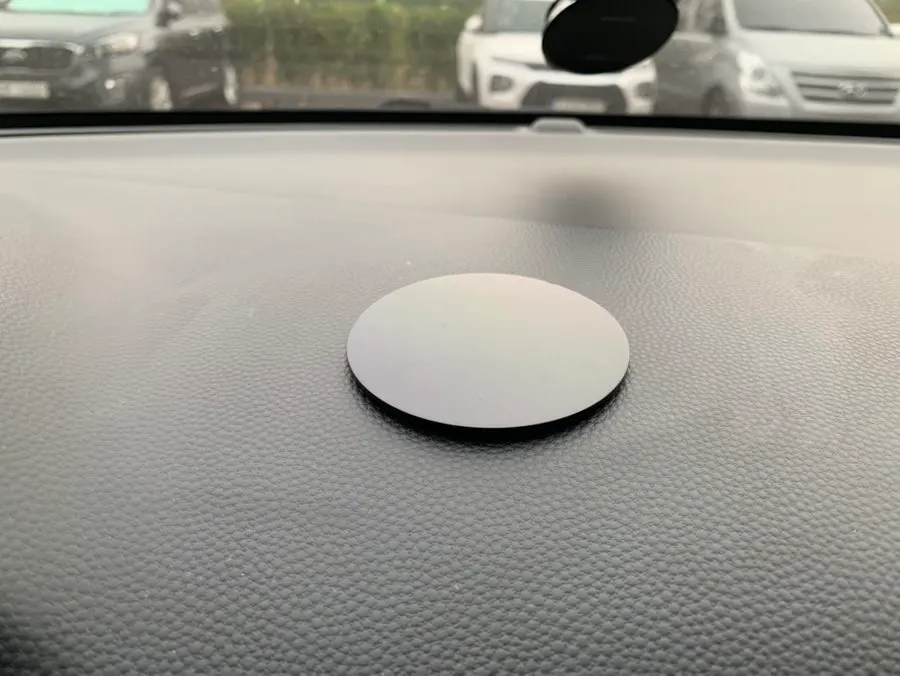Round dashboard pad with separate adhesive and suction surfaces