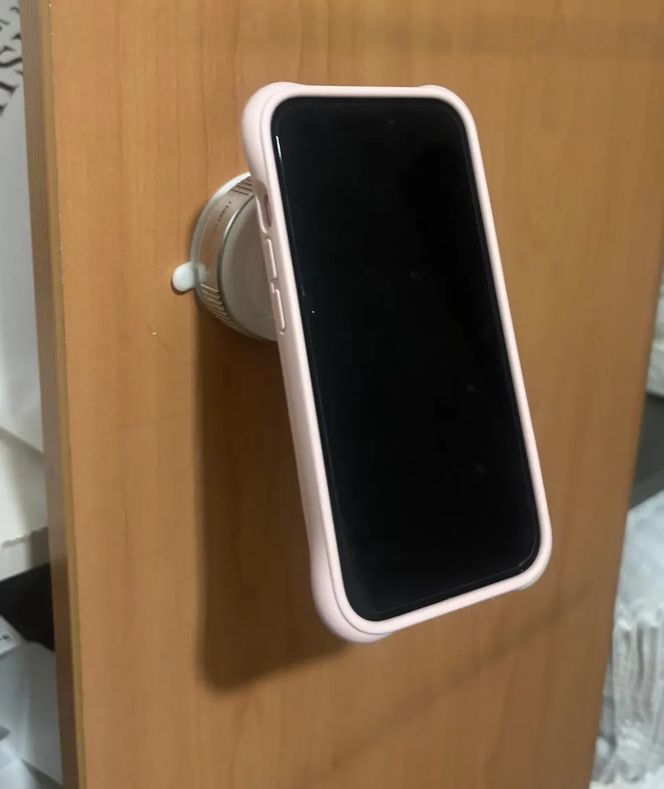 Phone mount secured by suction to a wall