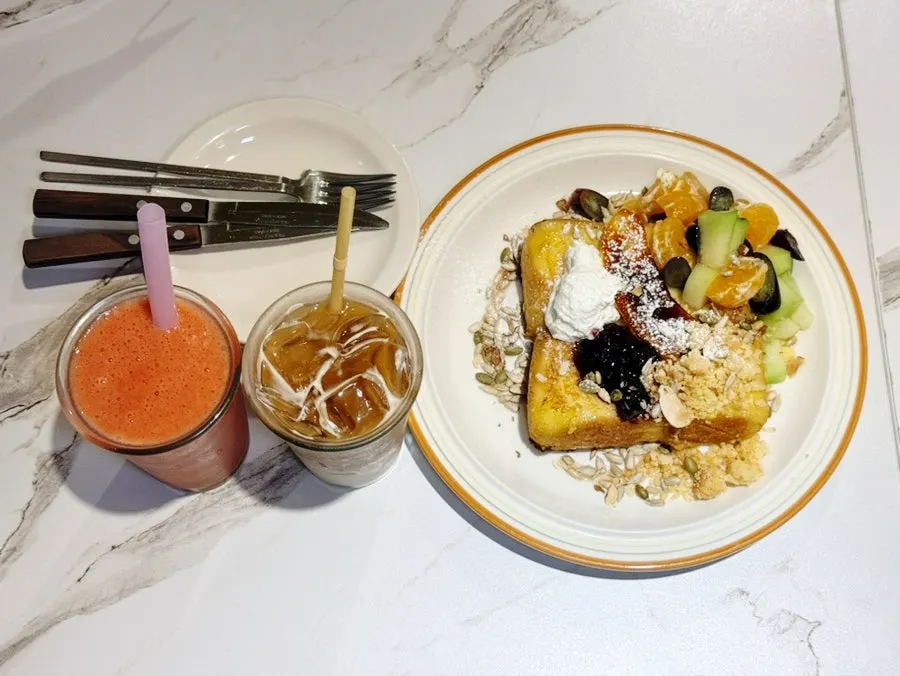 Table setting with French toast, Strawberry Pineapple Juice and Iced Caffe Latte