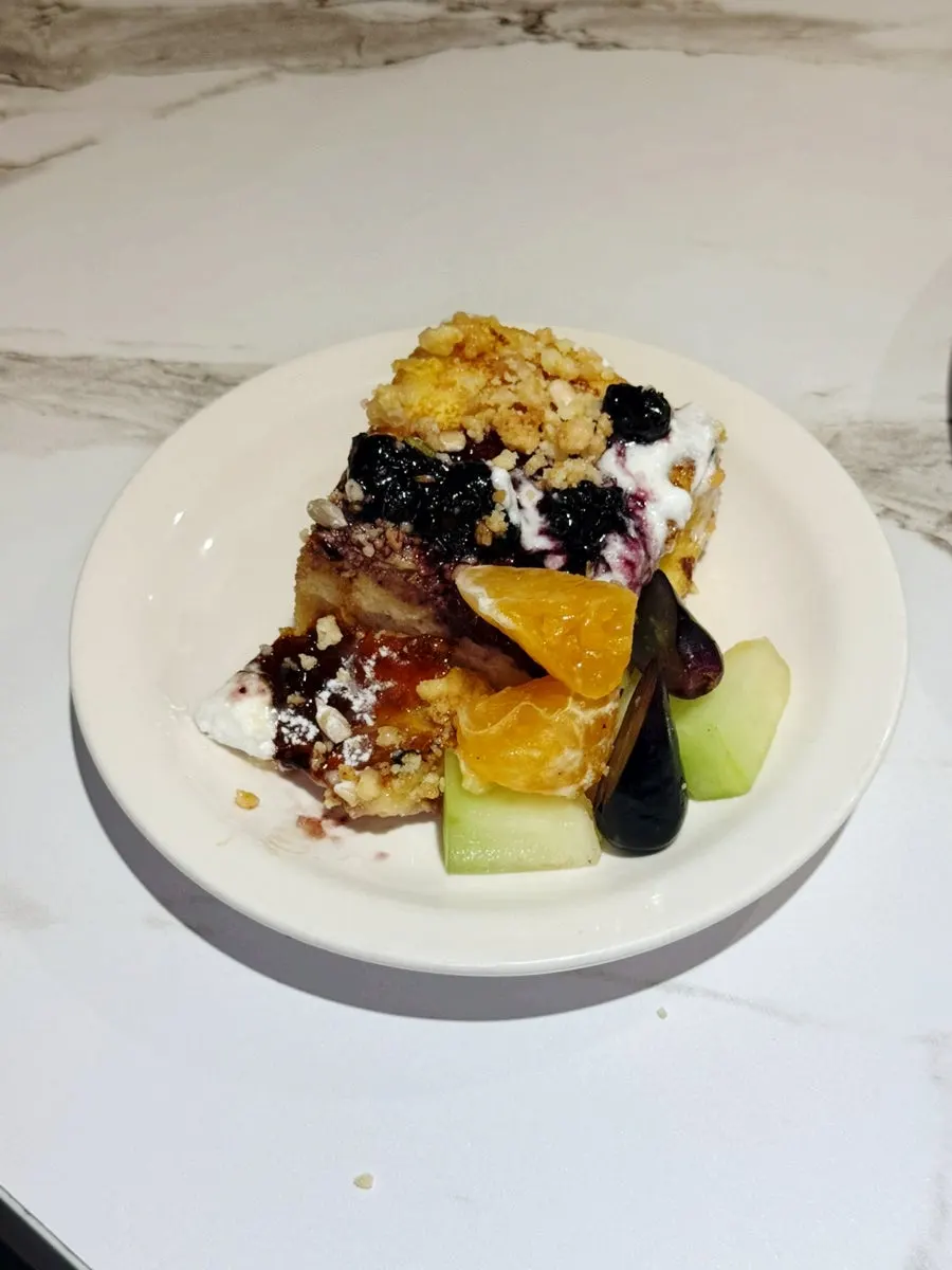 A bite of toast topped with nuts and sauce