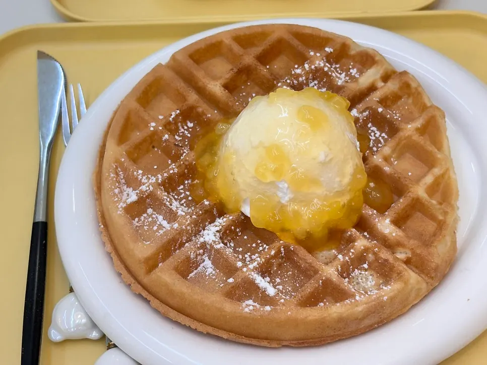 Apple cream waffle topped with whipped cream and apple jam
