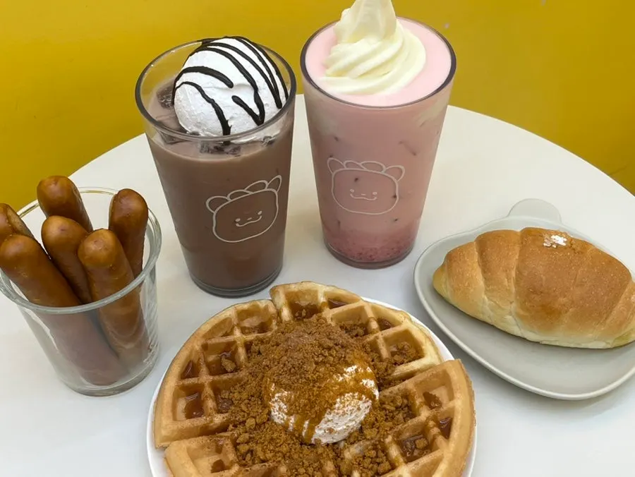 Table full of a waffle and two lattes