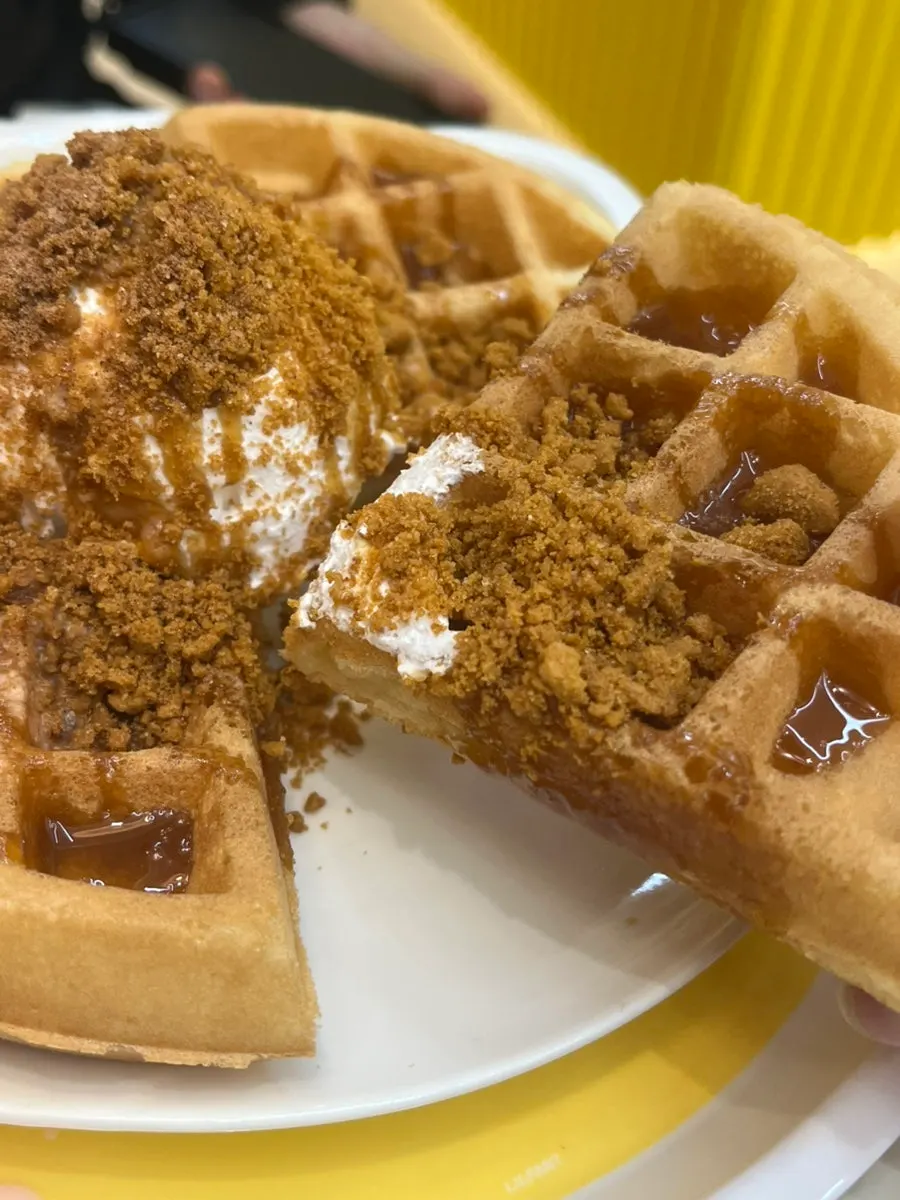 Waffle topped with ice cream and lotus crumble