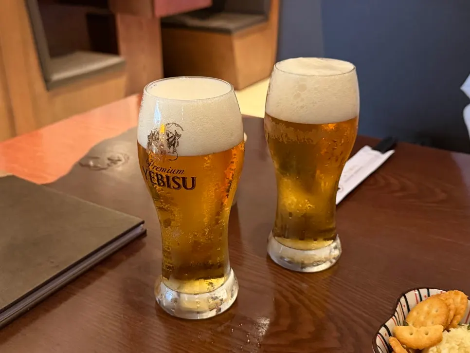 A glass of draft Ebisu beer with foam on top