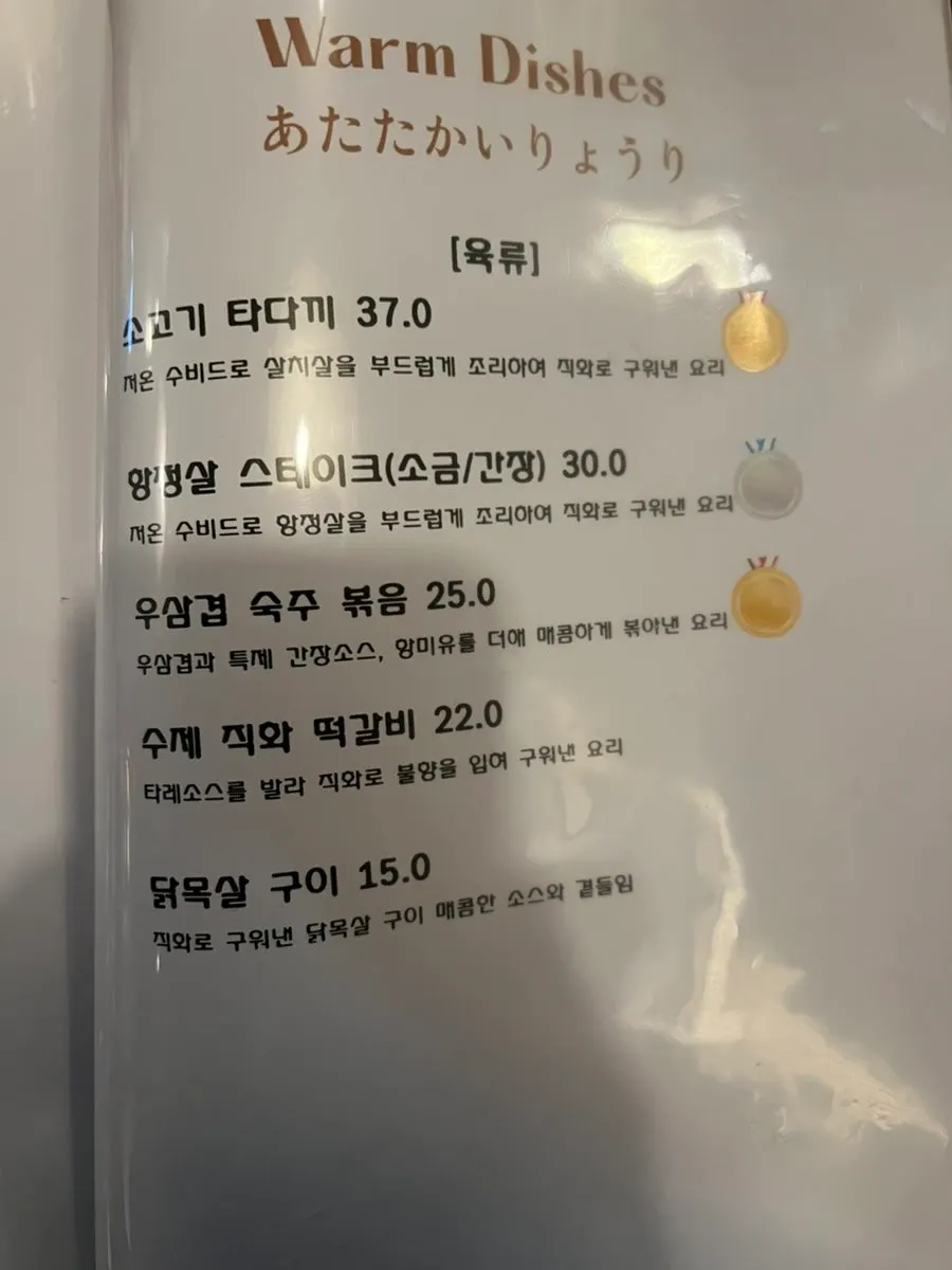 Menu board listing steak and pasta at Wakoan