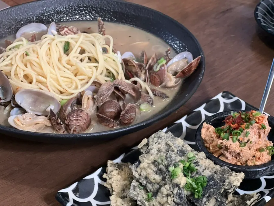 Broth and added noodles in the clam sake stew