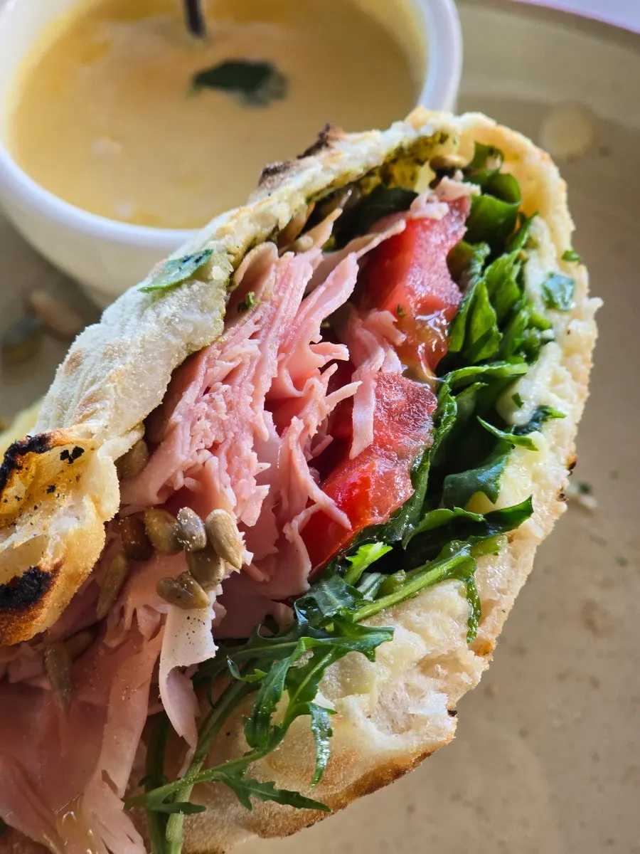 Cross-section of panuozzo packed with arugula and mortadella ham