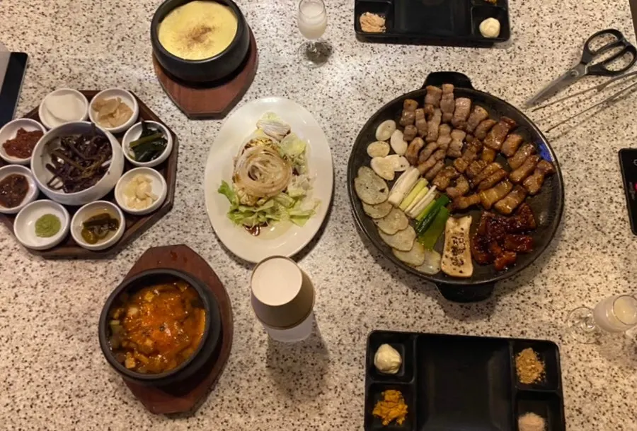 주물팬 위에 플레이팅된 삼겹살과 감자, 파, 떡