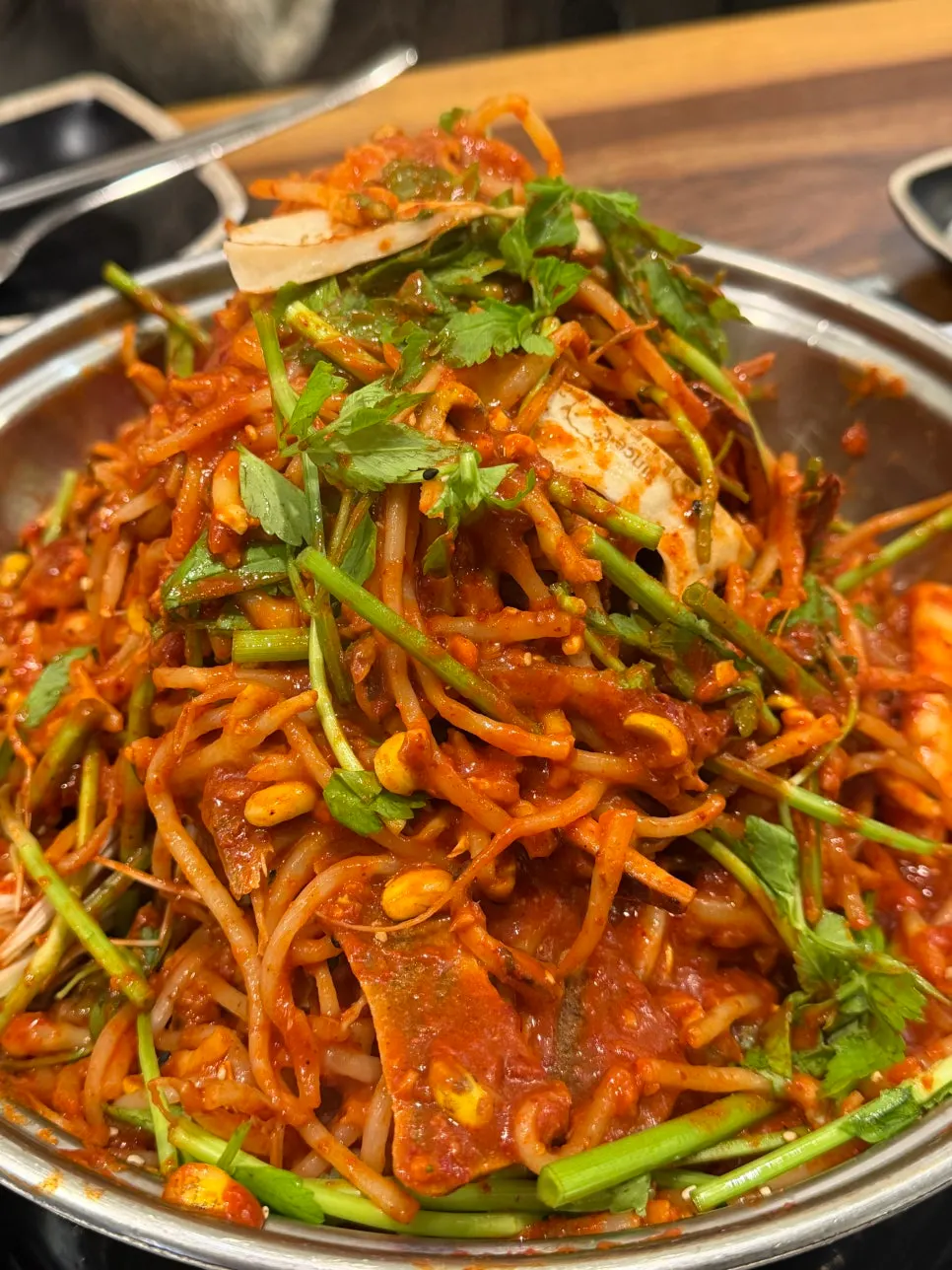 Spicy bone-in stew topped with minari and mushrooms