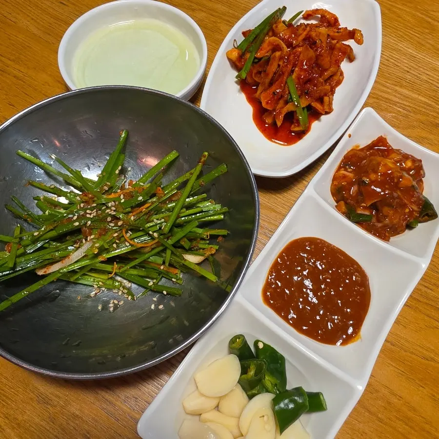 Standard side dish spread with spicy salted oyster, ssamjang, and radish pickles