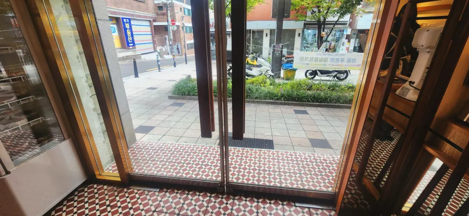 패턴 바닥과 어두운 소파의 카페 인테리어