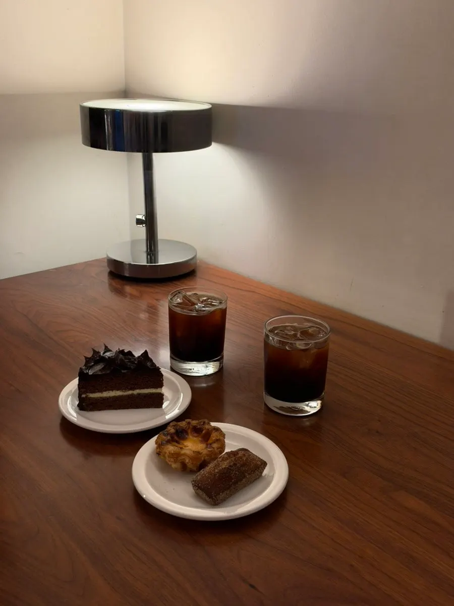 Desserts and coffee set out on the table next to the counter