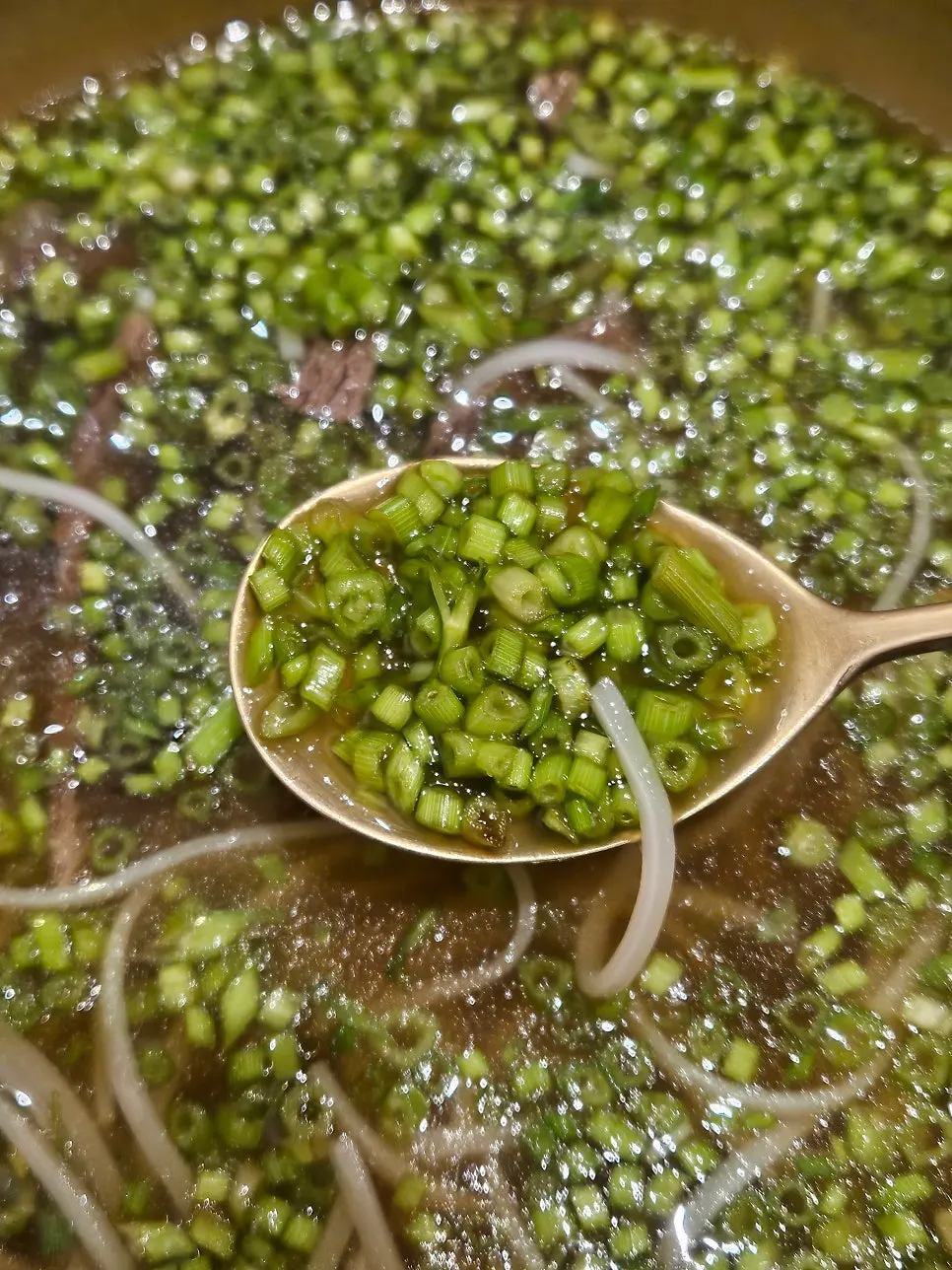 A spoonful of minari and gomtang broth
